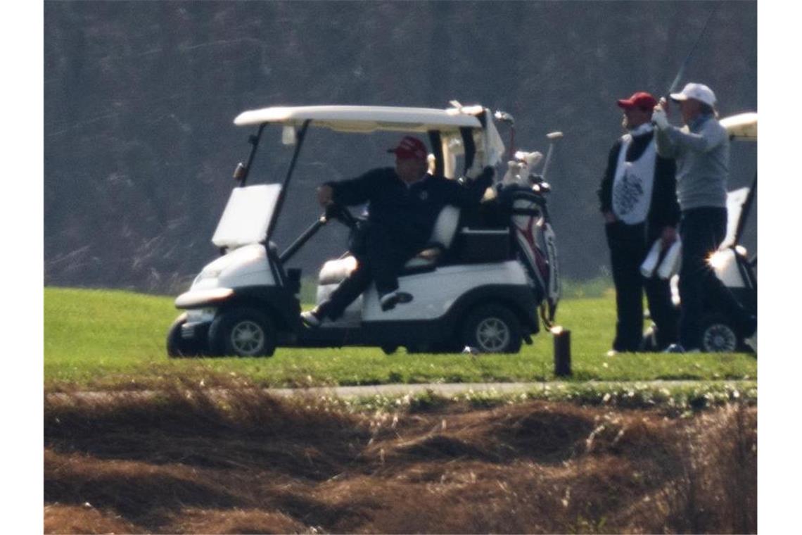 Donald Trump sitzt im Trump National Golf Club am Ufer des Potomac Flusses in einem Golfcart. Foto: Manuel Balce Ceneta/AP/dpa