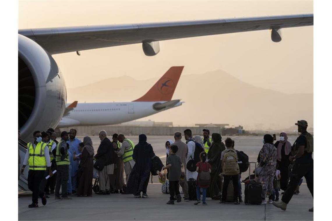 Doppelstaatler, deren Ausreise erlaubt wurde, besteigen in Kabul ein Flugzeug der Fluggesellschaft Qatar Airways. Foto: Bernat Armangue/AP/dpa