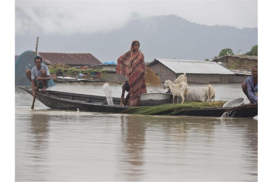 Dorfbewohner fahren mit einem Boot entlang des Flusses Brahmaputra. Heftiger Monsunregen und Gewitter haben in Südasien zahlreiche Überschwemmungen ausgelöst. Foto: Anupam Nath/AP