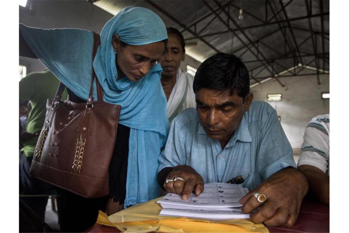 Indien: Zwei Millionen droht Abschiebung nach Bangladesch Dorfbewohner überprüfen in der Liste des National Register of Citizens (NRC) in Assam ihre Namen. Foto: Anupam Nath/AP