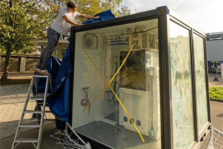 Dorian Lehmann entfernt die Plane von dem teilverglasten Zehn-Fuß-Überseecontainer. Er enthält das Herzstück der Anlage: die Brennstoffzelle und die Elektrolyse. Fotos: Alexander Becher