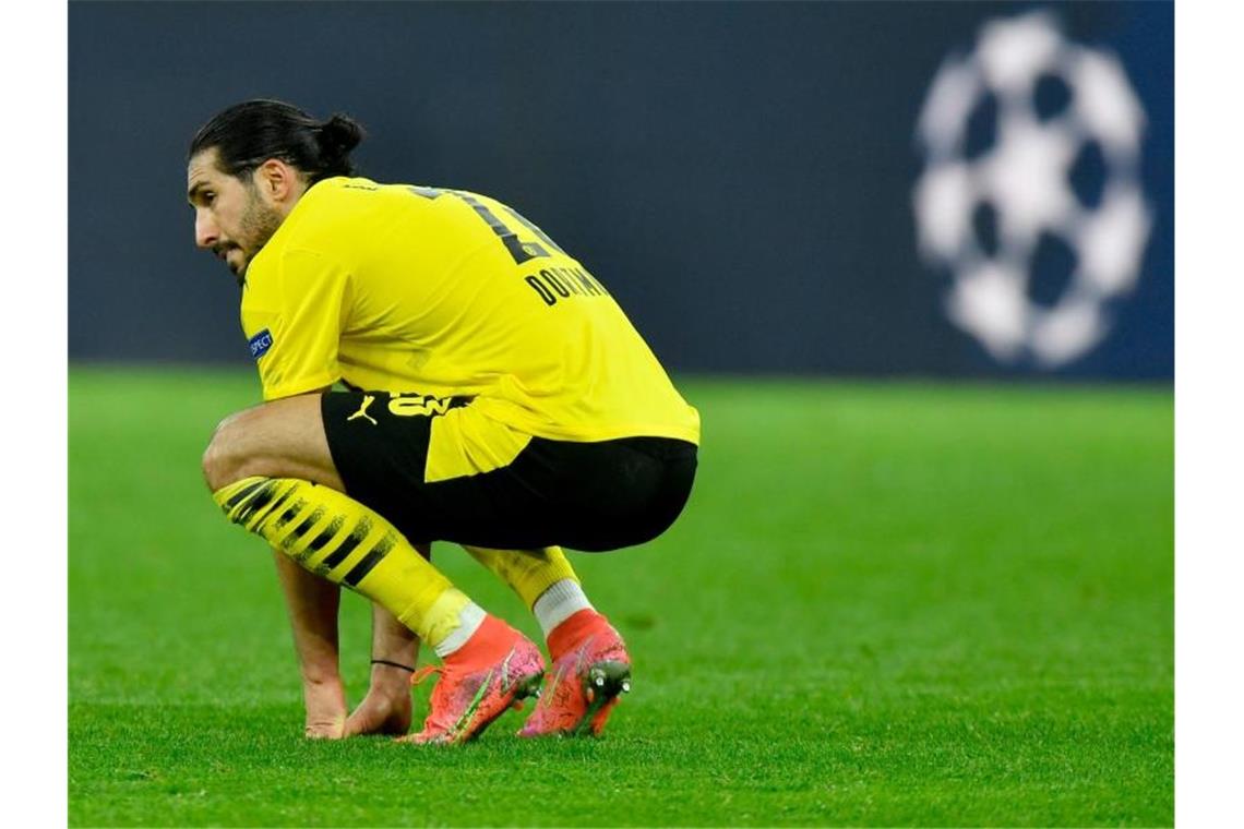 Dortmunds Emre Can hockt nach dem Aus in der Champions Leaague auf dem Spielfeld. Foto: Martin Meissner/AP-Pool/dpa