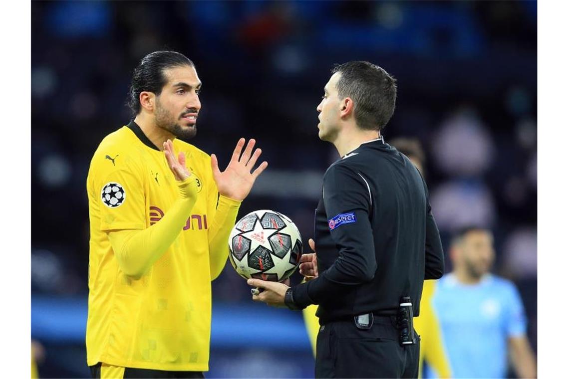 BVB verpasst Coup in Manchester: 1:2 nach achtbarem Kampf Dortmunds Emre Can (l) diskutiert mit Schiedsrichter Ovidiu Alin Hategan. Foto: Lindsey Parnaby/dpa
