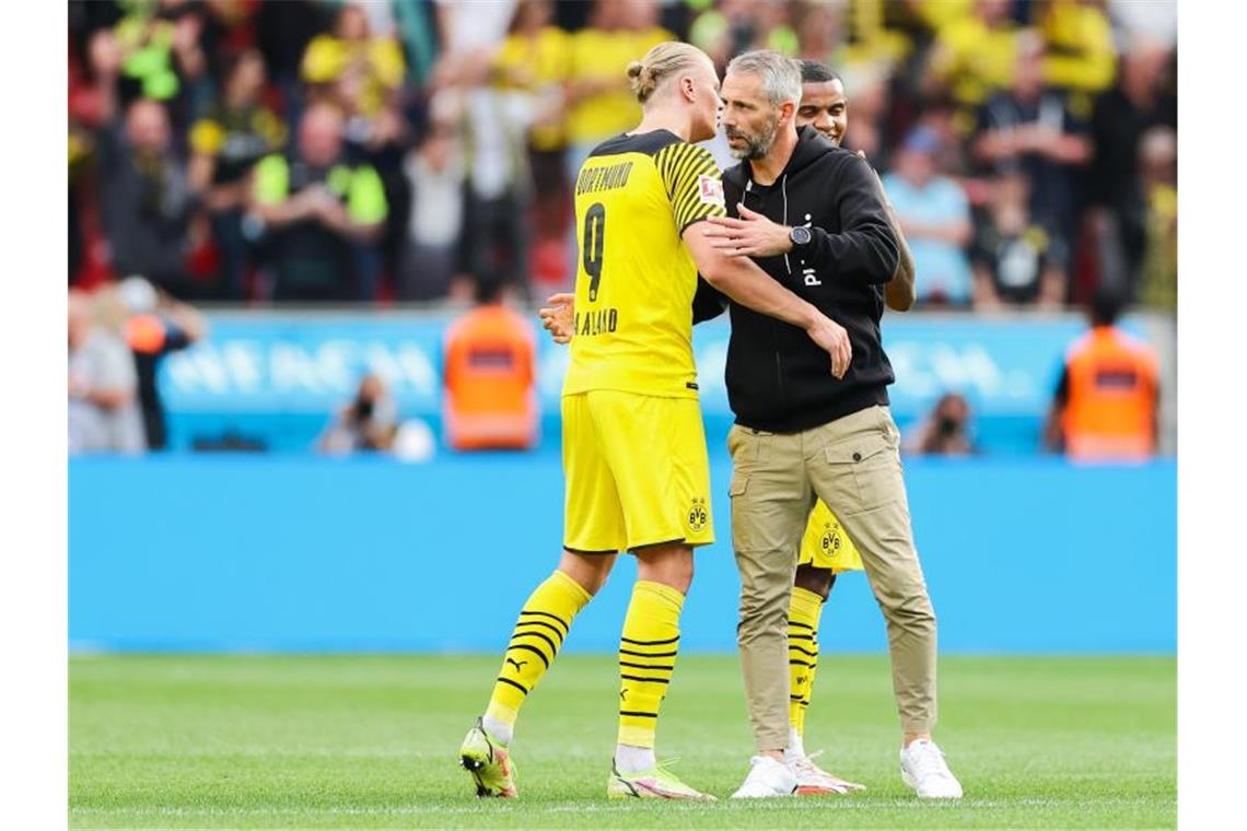 Dortmunds Erling Haaland (l) und Trainer Marco Rose umarmen sich nach einem Sieg. Foto: Rolf Vennenbernd/dpa