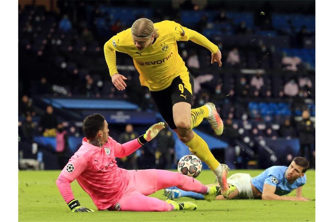 Dortmunds Erling Haaland (M) kommt mit dem Ball nicht an Manchesters Torwart Ederson vorbei. Foto: Lindsey Parnaby/dpa