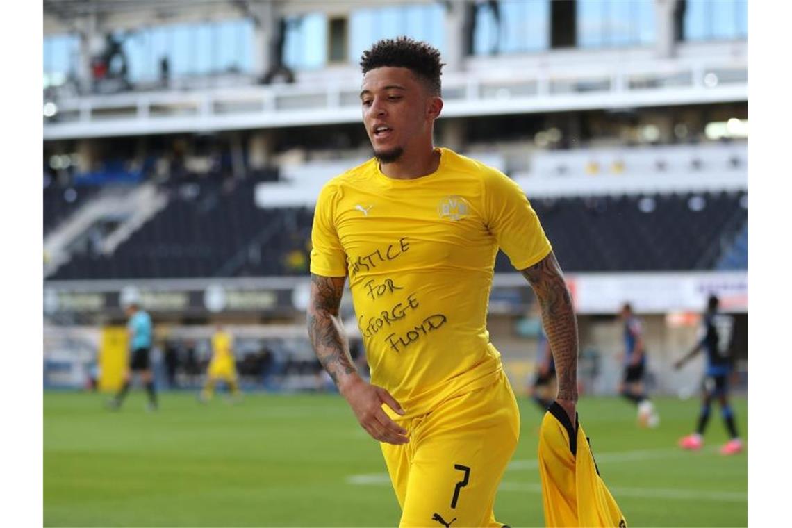 Dortmunds Jadon Sancho zeigt beim ersten seiner drei Tore gegen Paderborn ein Shirt mit dem Schriftzug „Justice for George Floyd“. Foto: Lars Baron/Getty Images Europe/Pool/dpa