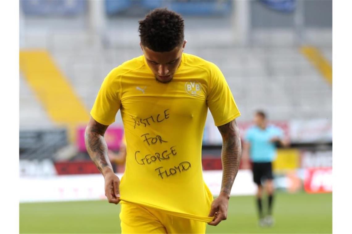 Dortmunds Jadon Sancho zeigt nach seinem ersten Tor gegen Paderborn ein Shirt mit dem Schriftzug „Justice for George Floyd“. Foto: Lars Baron/Getty Images Europe/Pool/dpa