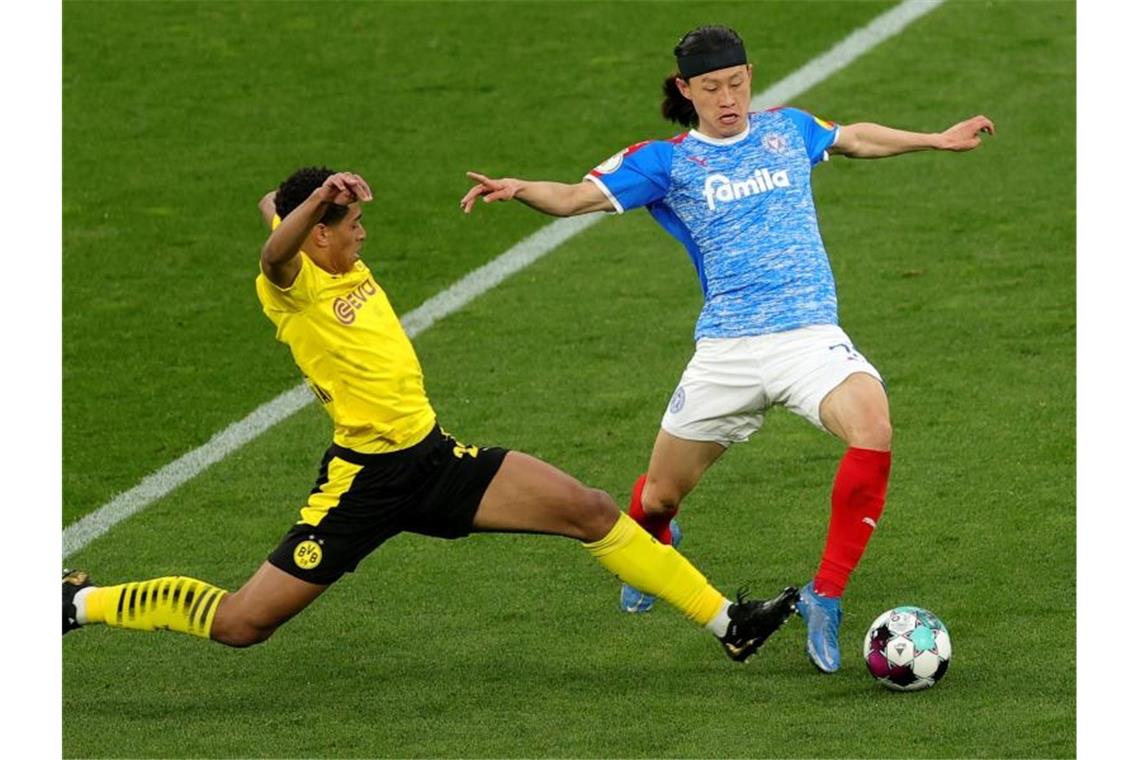Morey-Verletzung trübt BVB-Freude über Finaleinzug Dortmunds Jude Bellingham (l) im Zweikampf mit Kiels Jae-Sung Lee. Foto: Friedemann Vogel/epa Pool/dpa