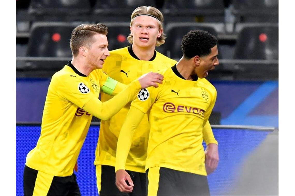 Dortmunds Jude Bellingham (r) jubelt nach seinem Treffer zum 1:0 mit seinen Teamkollegen Erling Haaland (M) und Marco Reus. Foto: Martin Meissner/AP-Pool/dpa