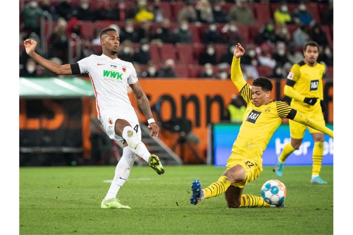 Nächster Frust für Dortmund: Nur 1:1 in Augsburg Dortmunds Jude Bellingham (r) versucht den Schuss des Augsburgers Reece Oxford zu blocken. Foto: Matthias Balk/dpa