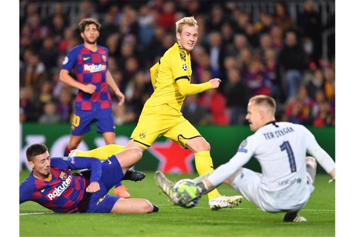 Dortmunds Julian Brandt (M) scheitert an Barcelonas Torwart Marc-Andre ter Stegen. Foto: Marius Becker/dpa