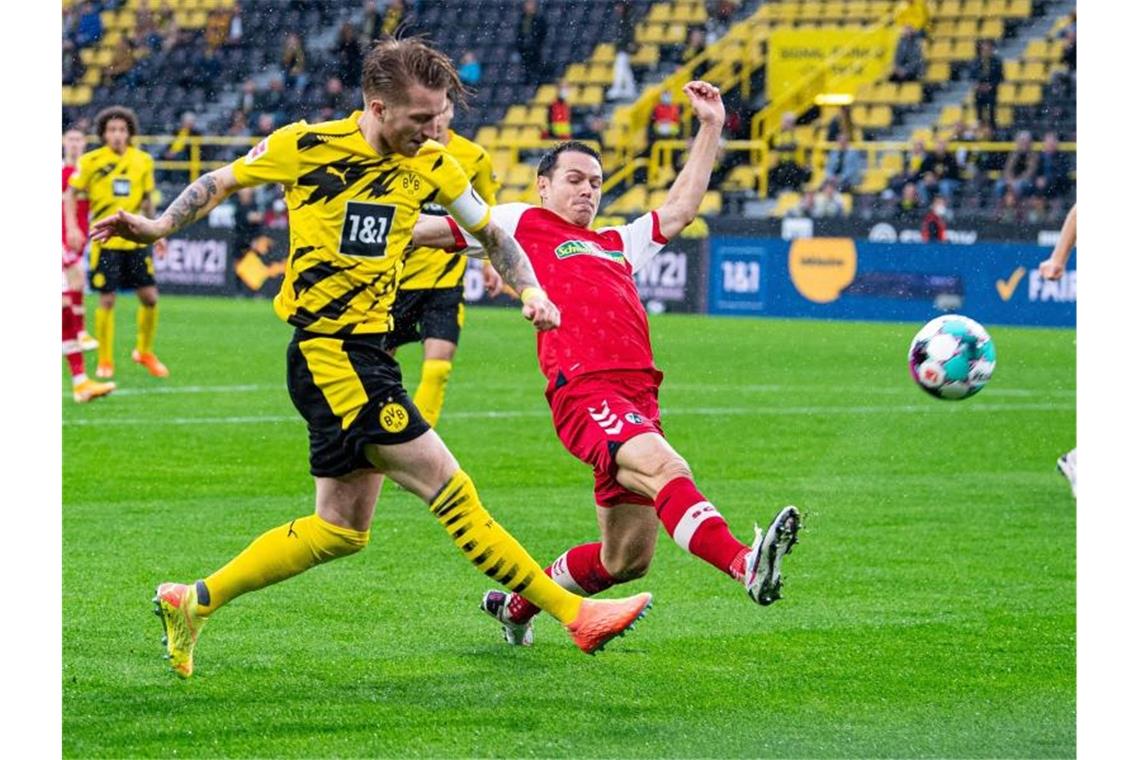 BVB wendet Saison-Fehlstart ab: 4:0 über Freiburg Dortmunds Marco Reus und Freiburgs Nicolas Höfler (l-r.) in Aktion. Foto: Guido Kirchner/dpa
