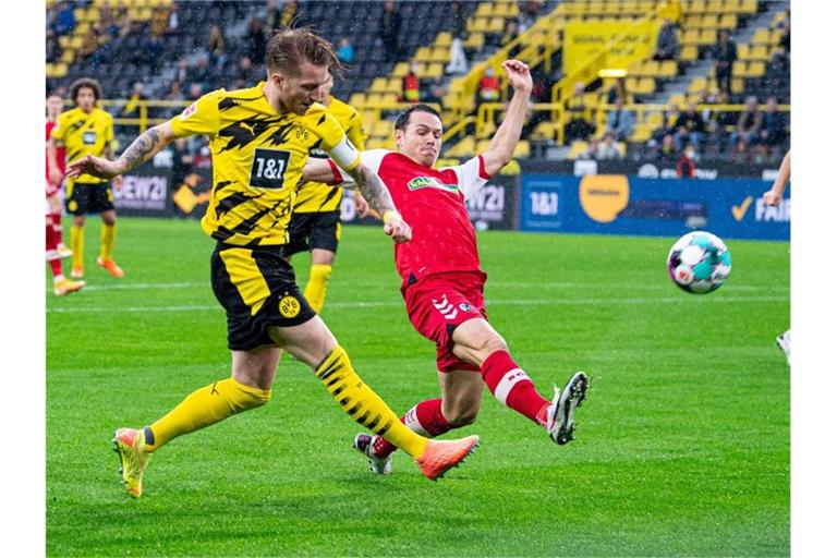 Dortmunds Marco Reus und Freiburgs Nicolas Höfler (l-r.) in Aktion. Foto: Guido Kirchner/dpa