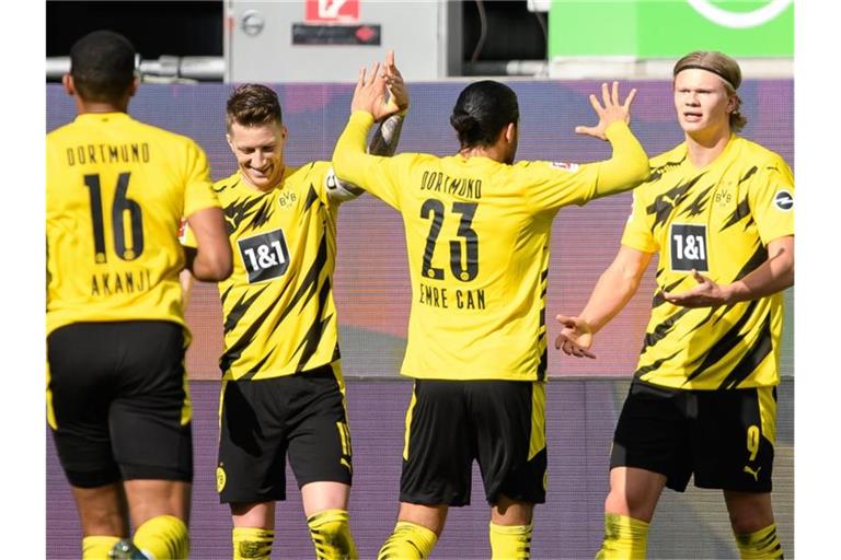 Dortmunds Matchwinner Erling Haaland (r) wird von seinen BVB-Teamkollegen in Wolfsburg gefeiert. Foto: Swen Pförtner/dpa