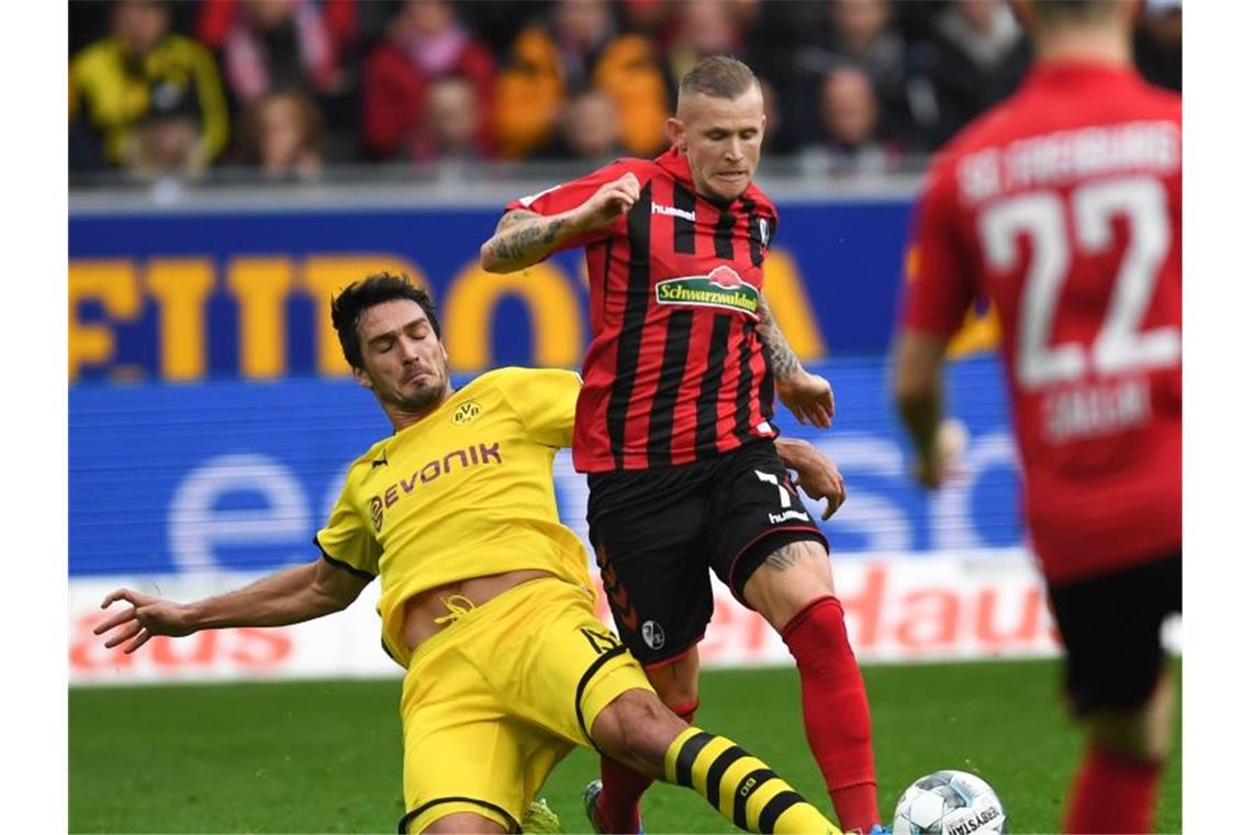 Dortmund gegen neuen Tabellenzweiten SCF nur 2:2 Dortmunds Mats Hummels (l.) kämpft mit Jonathan Schmid von Freiburg um den Ball. Foto: Patrick Seeger/dpa