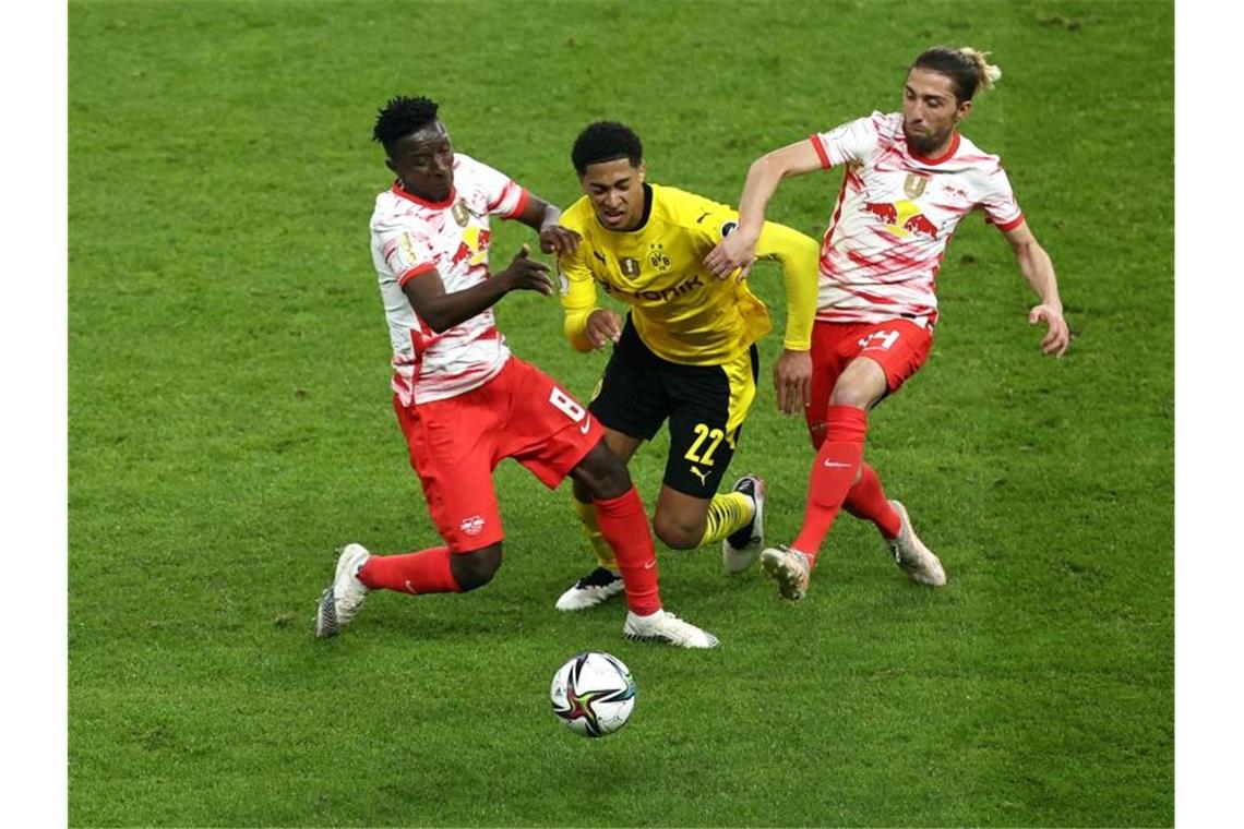 Dortmunds Mittelfeldspieler Jude Bellingham (M) wird von Leipzigs Amadou Haidara (l) und Kevin Kampl (r) in die Zange genommen. Foto: Maja Hitij/Getty-Pool/dpa