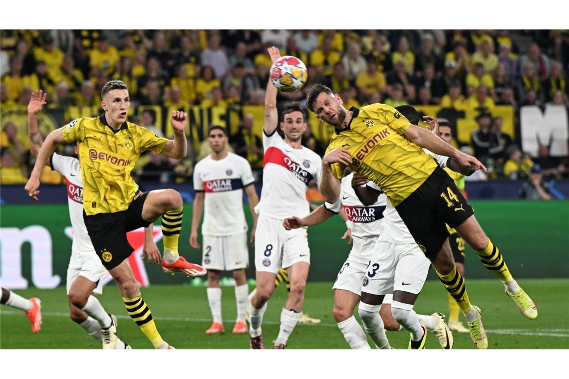 Dortmunds Niclas Füllkrug (r) kommt zum Kopfball - er erziehlt gegen Paris Saint-Germain das entscheidende Tor in der Champions League.