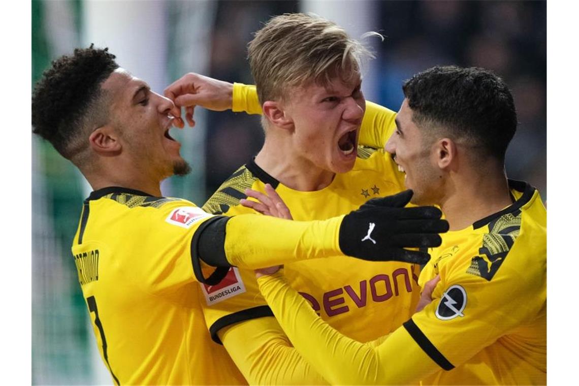 Dortmunds Stürmer Erling Haaland (M) bejubelt seinen Treffer gegen Werder Bremen mit Jadon Sancho (l) und Achraf Hakimi. Foto: Peter Steffen/dpa