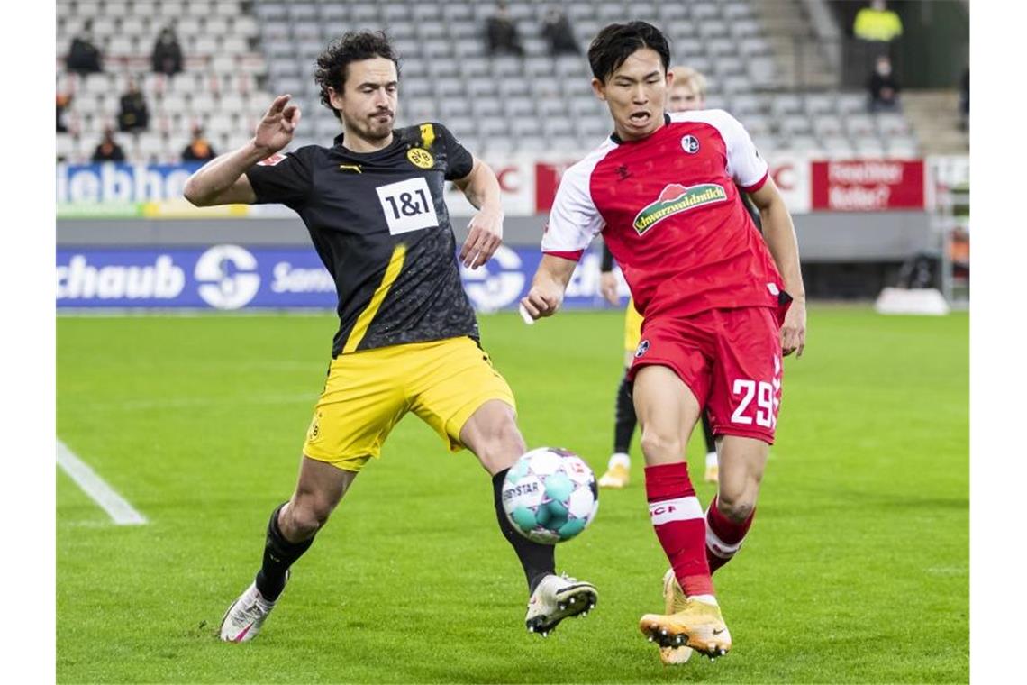 Hummels, Reus und Co. patzen: Dortmund verliert in Freiburg Dortmunds Thomas Delaney (l) in Aktion gegen Freiburgs Woo-yeong Jeong. Foto: Tom Weller/dpa
