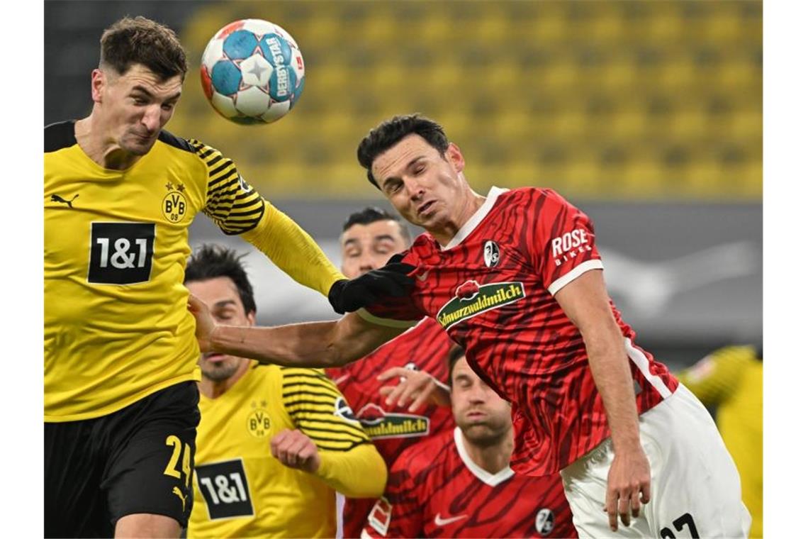 „Schnell vergessen“: Freiburger Fokus auf Pokal Dortmunds Thomas Meunier (l) im Kopfballduell mit Freiburgs Nicolas Höfler. Foto: David Inderlied/dpa