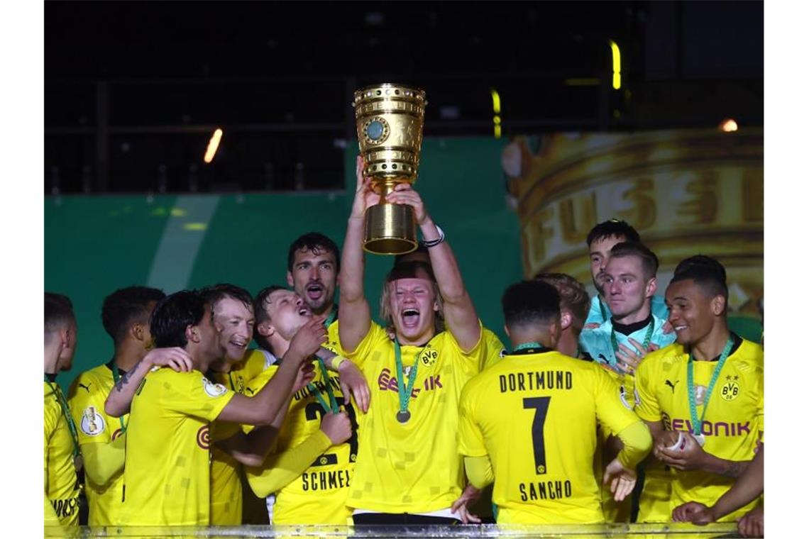 BVB feiert Pokalsieg nach Sieg gegen Leipzig Dortmunds Top-Stürmer Erling Haaland hebt den Pokal in die Höhe. Der BVB hat den DFB-Pokal zum fünften Mal gewonnen. Foto: Martin Rose/Getty-Pool/dpa
