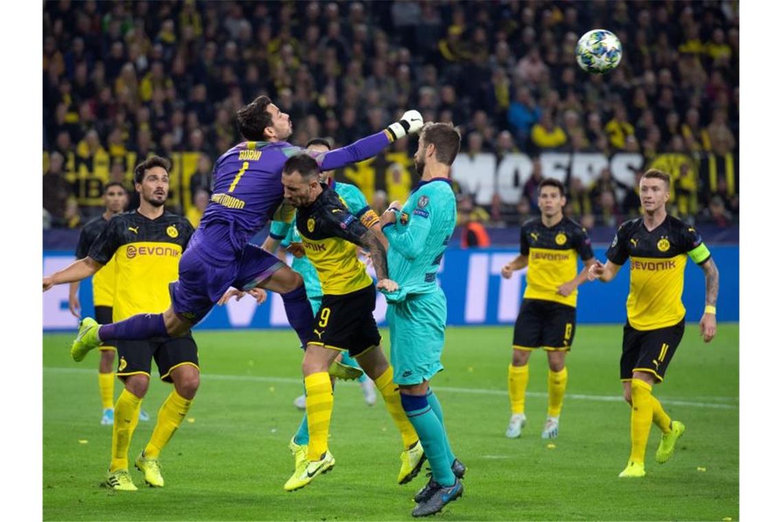Dortmunds Torwart Roman Bürki faustet neben Paco Alcacer den Ball fort. Foto: Bend Thissen