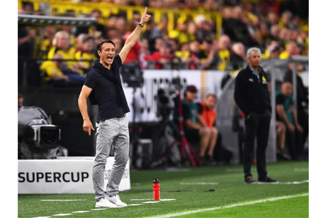 Dortmunds Trainer Lucien Favre (r) und Bayerns Trainer Niko Kovac stehen an der Seitenlinie. Foto: Marius Becker