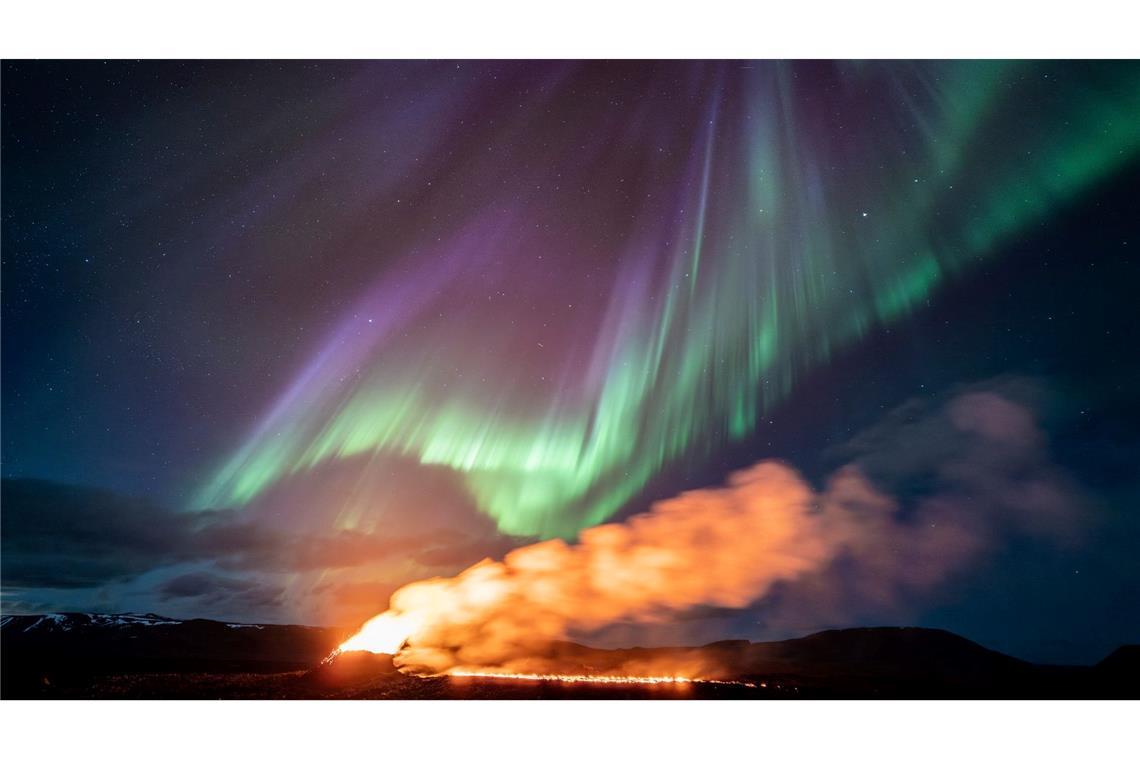 Dramatische Natur: Nordlichter treffen nahe der Stadt Grindavik auf einen Vulkanstrom. Der Vulkan im Südwesten Islands, der im Dezember, Januar und Februar dreimal ausbrach und Lava in Richtung einer nahe gelegenen Gemeinde schickte, bricht weiter aus.