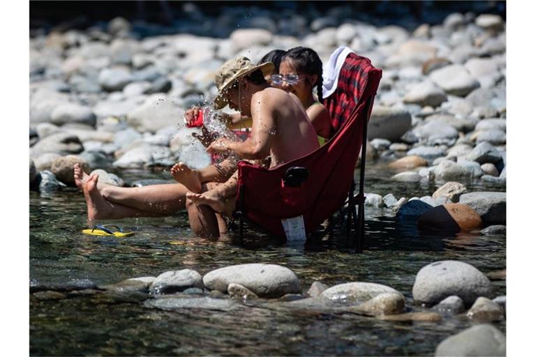 Drei hitzegeplagte Kanadier kühlen sich im kalten Wasser des Lynn Creek ab. Bis zu 47,9 Grad - Kanada höchste je gemessene Temperatur - wurde im Südwesten des Landes erreicht. Foto: Darryl Dyck/The Canadian Press via ZUMA/dpa