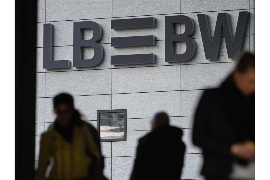 Drei Menschen gehen vor dem Schriftzug der Landesbank Baden-Württemberg (LBBW) entlang. Foto: Sebastian Gollnow/dpa/Archivbild