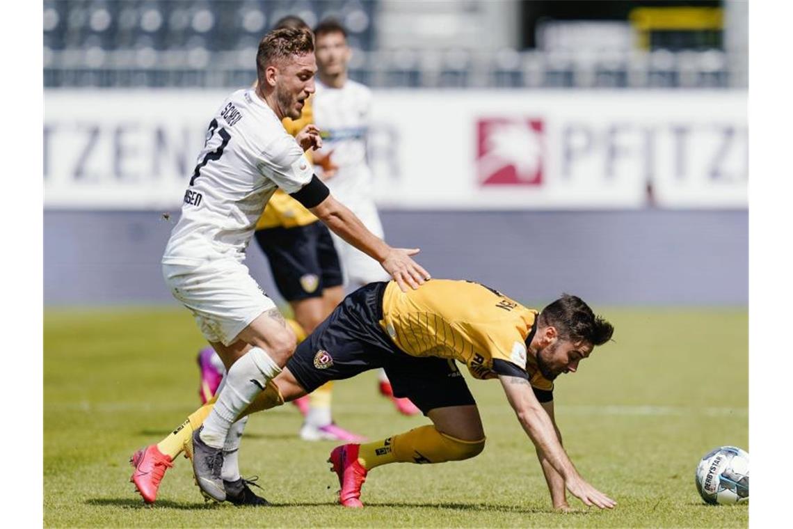 Dresdens Niklas Kreuzer (r) kommt im Zweikampf mit Sandhausens Robin Scheu ins Straucheln. Foto: Uwe Anspach/dpa