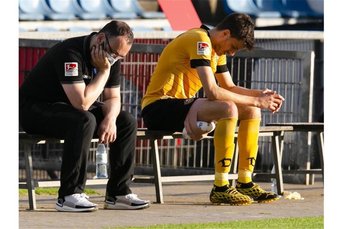 Dresdens Teammanager Martin Börner (l) und Dynamo-Spieler Alexander Jeremejeff ließen nach der Niederlage in Kiel die Köpfe hängen. Foto: Frank Molter/dpa
