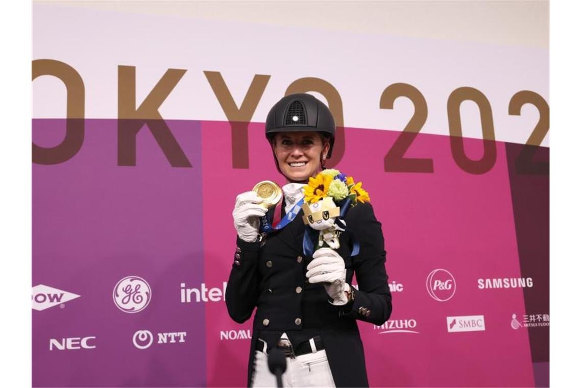 Dressurreiterin Jessica von Bredow-Werndl präsentiert ihre Goldmedaille. Foto: Friso Gentsch/dpa
