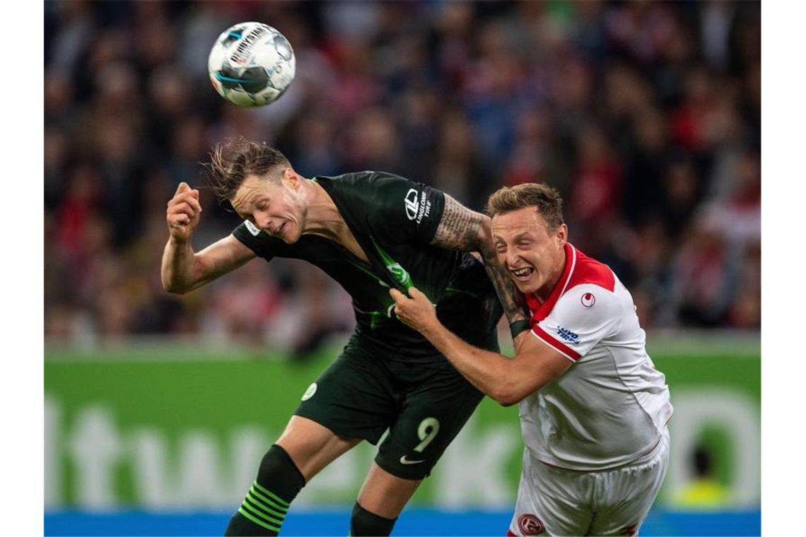 Düsseldorfs Robin Bormuth (r) und Wolfsburgs Wout Weghorst kämpfen um den Ball. Foto: Marius Becker