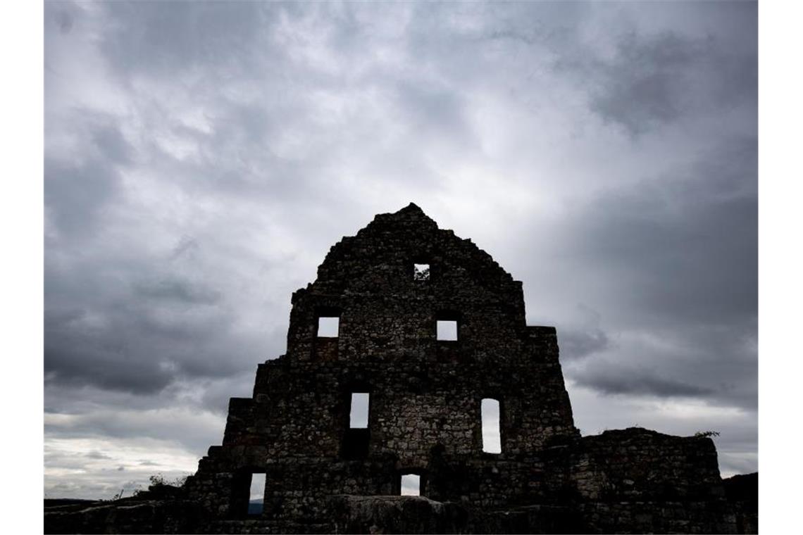 Dunkle Wolken ziehen an der Burgruine Hohenurach vorbei. Foto: Fabian Sommer/Archivbild