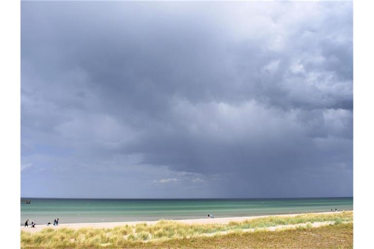 Dunkle Wolken ziehen an der Ostsee bei Prerow über das Meer. Foto: Stefan Sauer