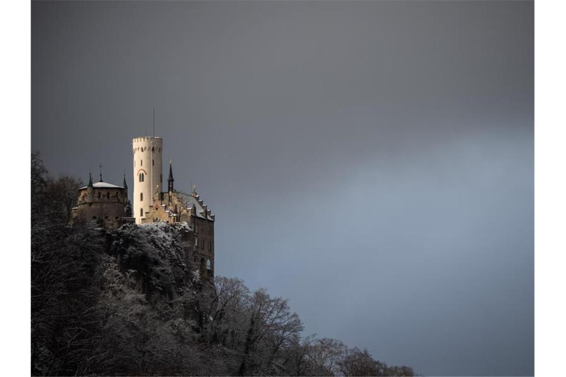 Ungemütlicher Start in die Woche: Regen, Gewitter, Schnee Dunkle Wolken ziehen über das Schloss Lichtenstein. Foto: Sebastian Gollnow/dpa/Archivbild