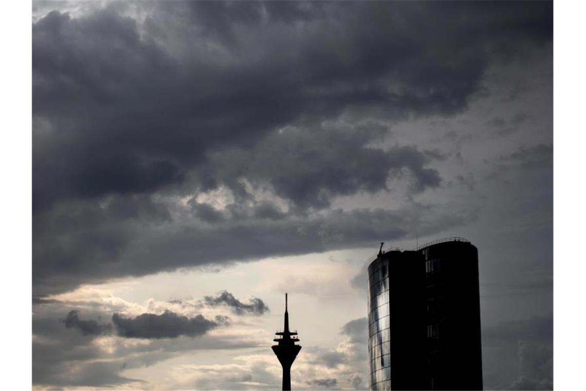Dunkle Wolken ziehen über den Rheinturm und das Hochhaus GAP 15 in Düsseldorf. Foto: Martin Gerten