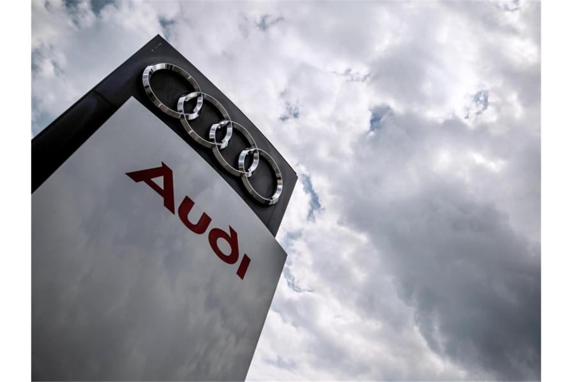 Dunkle Wolken ziehen über eine Stelel mit dem Audi-Logo und Schriftzug hinweg. Foto: Christoph Schmidt/dpa
