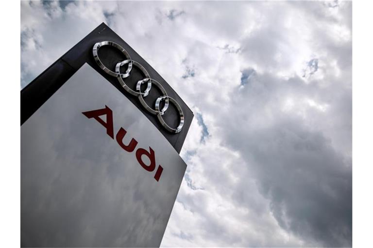 Dunkle Wolken ziehen über eine Stelel mit dem Audi-Logo und Schriftzug hinweg. Foto: Christoph Schmidt/dpa