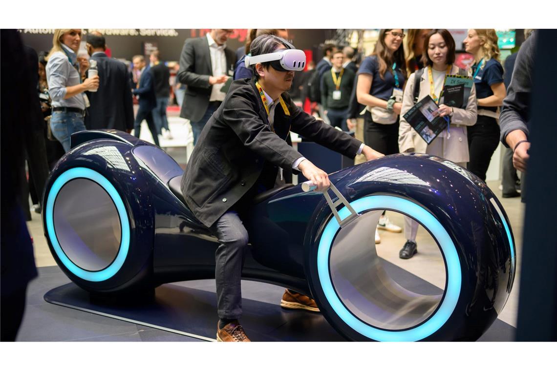 Durch eine Augmented-Reality-Brille schauend sitzt ein Gast auf einem fiktiven Gefährt bei der Industriemesse Hannover.