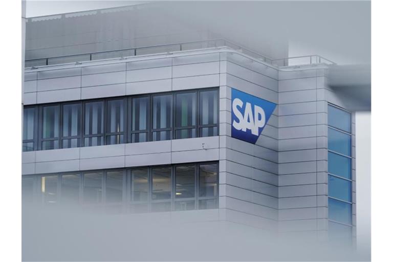 Durch eine Scheibe ist ein Logo des Softwarekonzerns SAP am Hauptgebäude zu sehen. Foto: Uwe Anspach/dpa/Symbolbild