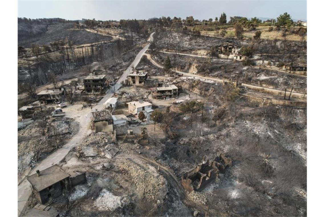 Waldbrände in Südeuropa toben weiter Durch einen Waldbrand zerstörte Häuser in der Türkei. Foto: Uncredited/AP/dpa