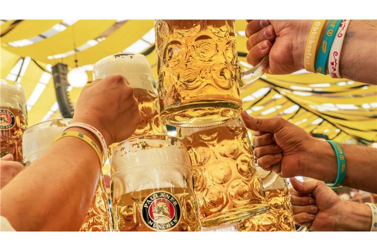 Durstige Besucher der Münchner Wiesn 2025 trinken die erste Mass Bier und  prosten sich  im Paulaner Festzelt zu.