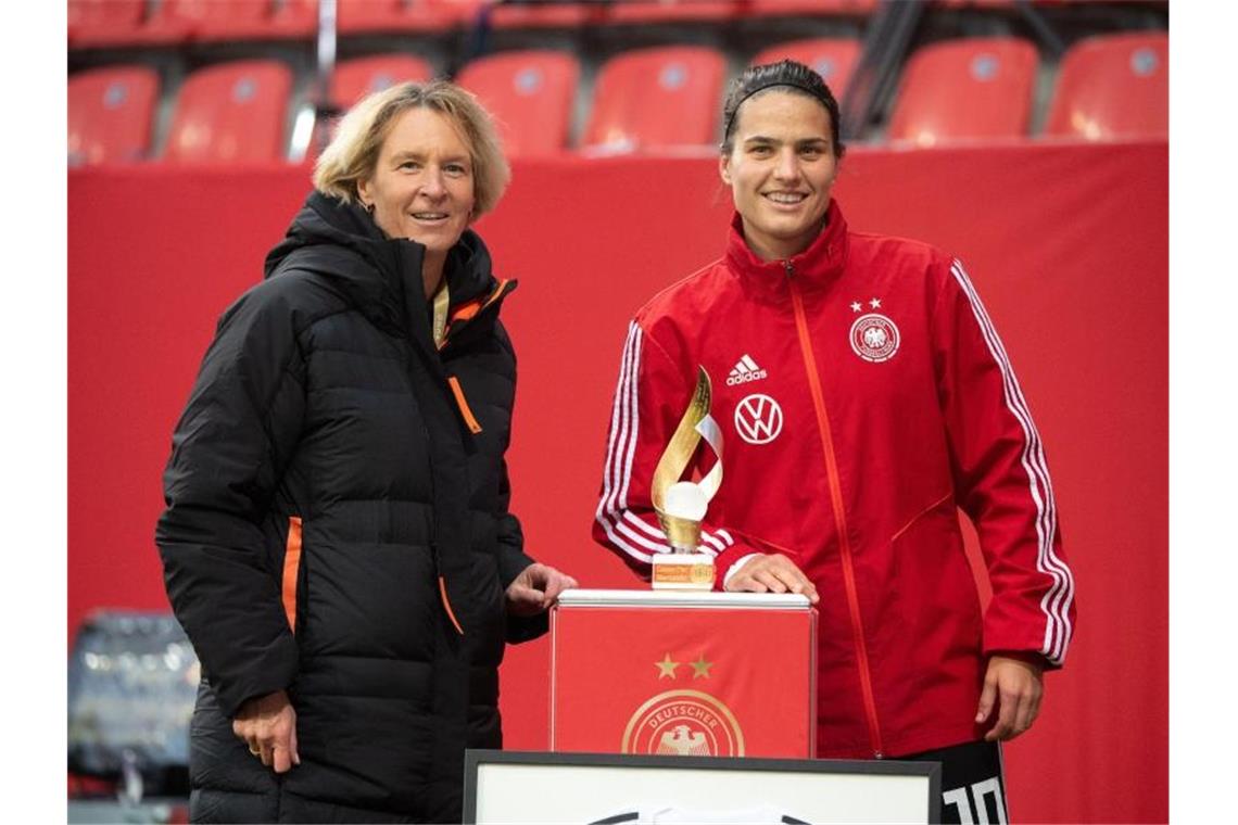 Dzsenifer Marozsan (r) wird vor der Partie für ihr hundertstes Länderspiel geehrt. Foto: Matthias Balk/dpa