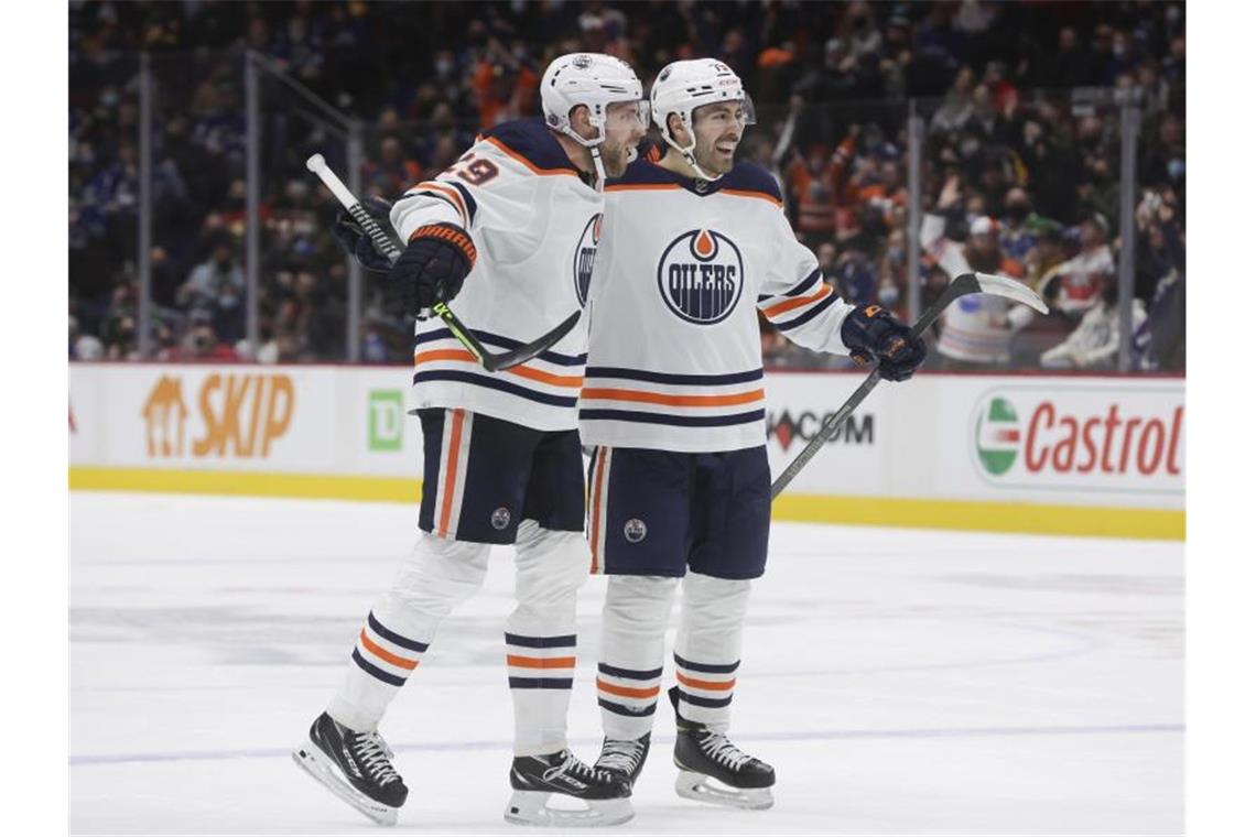 Edmontons Leon Draisaitl (l) und Teamkollege Evan Bouchard feiern Draisaitls Tor. Foto: Darryl Dyck/The Canadian Press/AP/dpa