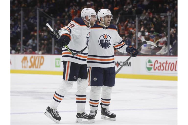 Edmontons Leon Draisaitl (l) und Teamkollege Evan Bouchard feiern Draisaitls Tor. Foto: Darryl Dyck/The Canadian Press/AP/dpa