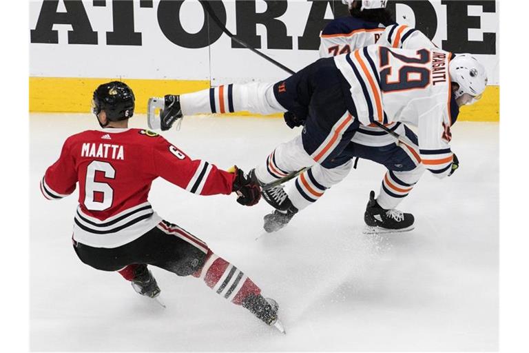 Edmontons Leon Draisaitl (r) wird durch Olli Maatta von den Chicago Blackhawks zu Fall gebracht. Foto: Jason Franson/The Canadian Press/AP/dpa
