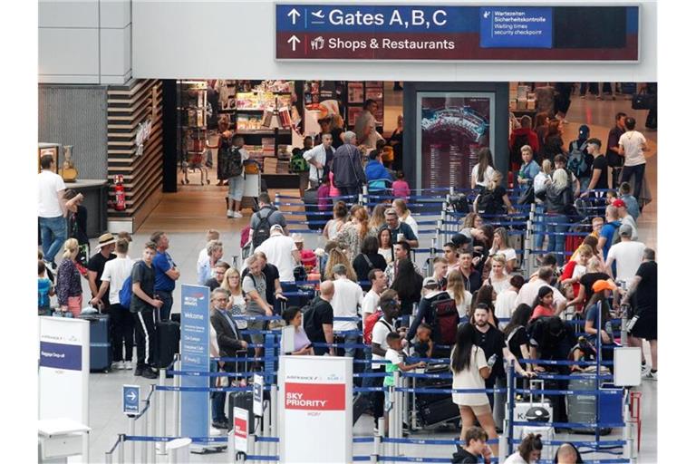Egal welches Fortbewegungsmittel gewählt wird. Für viele Reisende beginnt der Urlaub erstmal mit Warten: in Schlangen, im Stau, auf verspätete Züge. Hier warten Urlauber an den Check-In-Schaltern am Düsseldorfer Flughafen. Foto: Roland Weihrauch