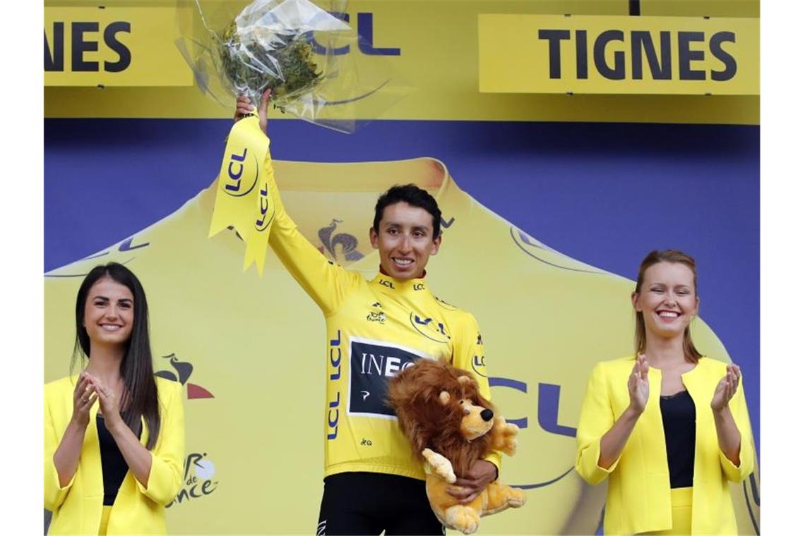 Egan Arley Bernal Gomez (M) steht im Gelben Trikot des Gesamtführenden auf dem Podium. Foto: Christophe Ena/AP